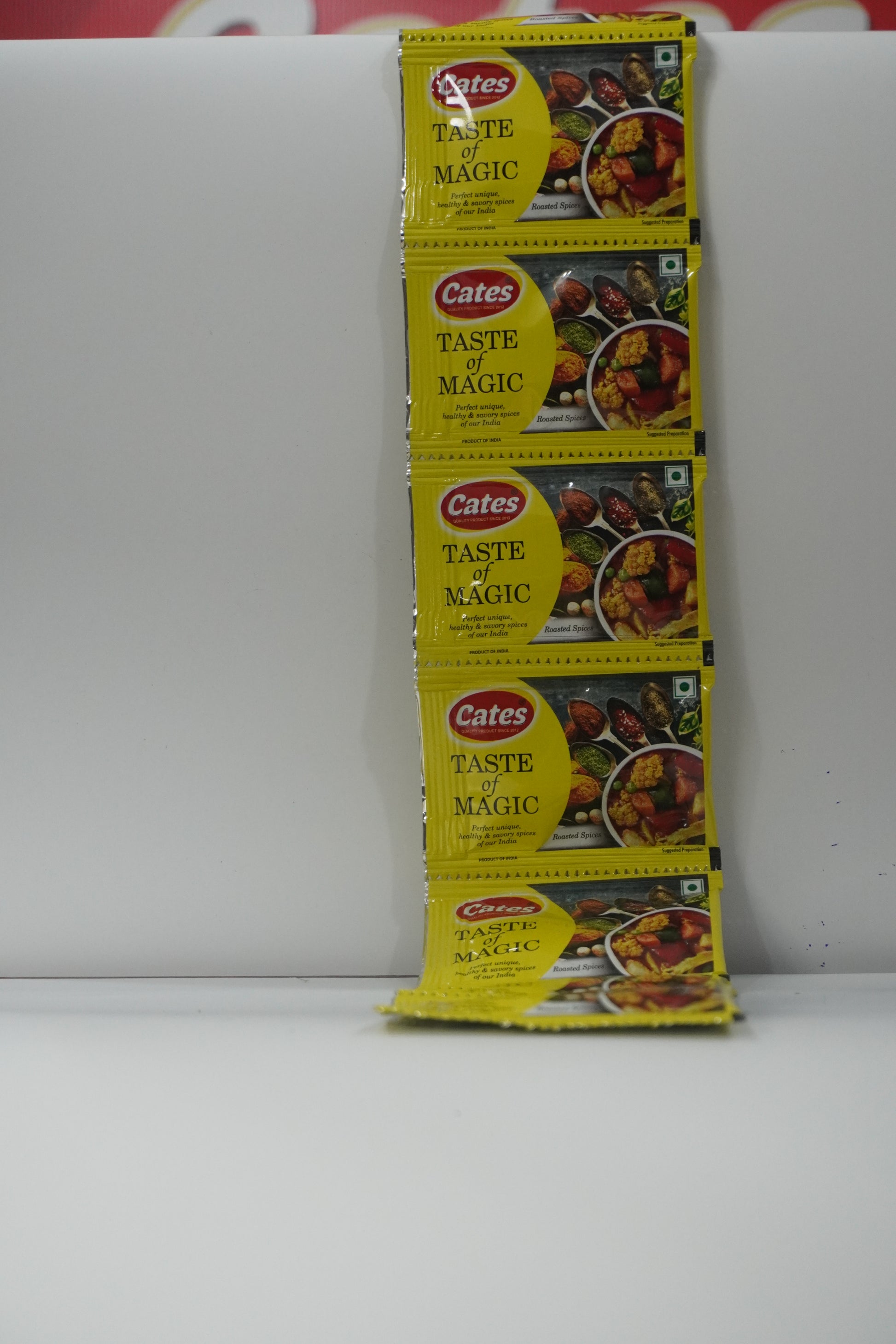 Multiple packets of 'Cater's Taste Magic' on a white surface